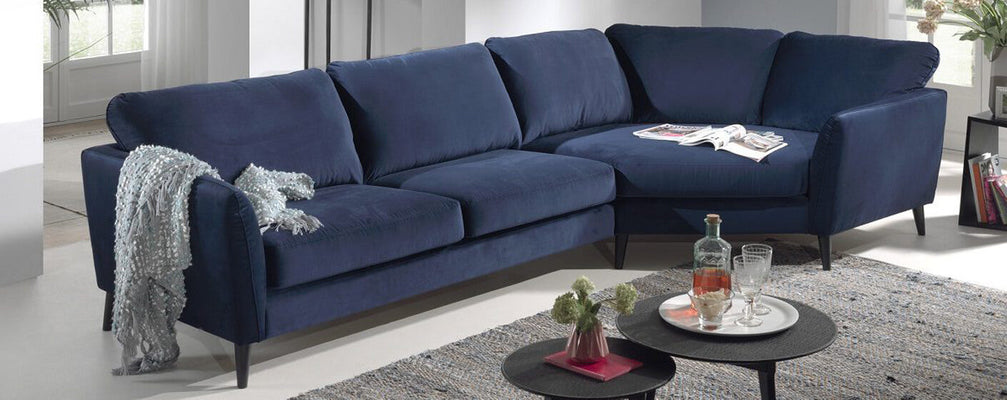 A modern living room featuring a comfortable corner sofa, complemented by soft fabric cushions and a sleek coffee table.