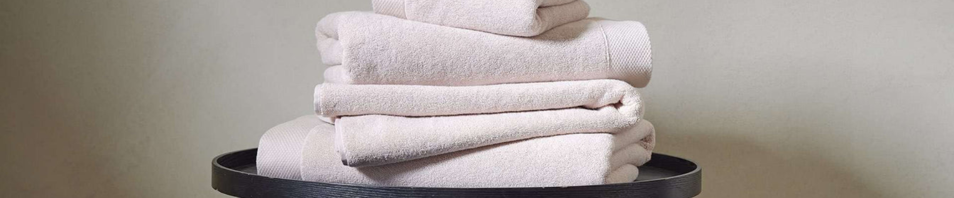 A display of premium quality towels including bath towels, hand towels, and quick dry towels in a stylish bathroom setting.