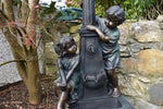 Eye-catching boy and girl garden ornament with a water-feature lamppost.