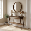 Wooden console table with decorative items in a room with a round mirror on the wall.