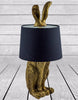 Decorative rabbit ears lamp in antique gold with black shade.