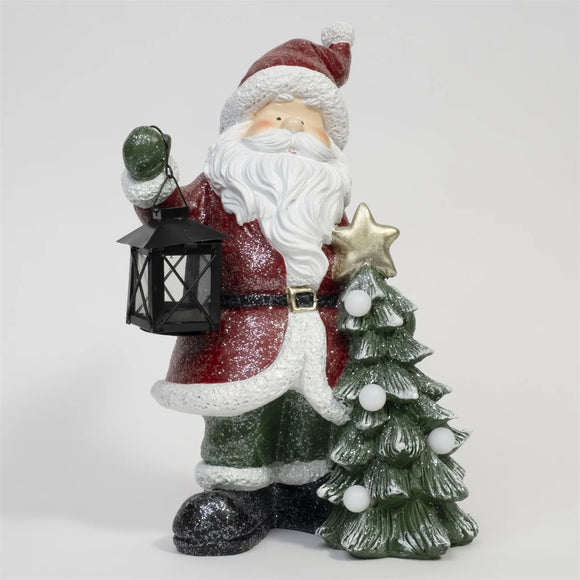 Elevate your holiday decor with the LED Santa figurine holding a lantern and a tree. Add a touch of festive charm and illumination to your space with this delightful and heartwarming holiday decoration