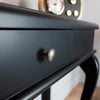 Black console table with intricate scroll design