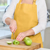 Love Colour Cotton Apron Ochre worn while preparing food in the kitchen