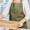 Love Colour Cotton Apron Olive Green worn while preparing food in the kitchen