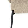 Close-up of a beige upholstered chair with a black metal leg on a white background