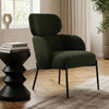 Green armchair in a stylish living room with a side table and decor elements.