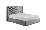 Plush ottoman bed in grey with button detailing.
