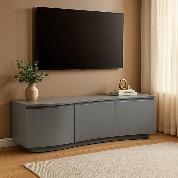 Gray TV stand with a television mounted on a beige wall, featuring decorative items.