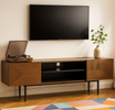 Wooden entertainment console with TV, record player, and decor in a living room.