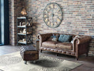Distressed rug in a room with a brick wall and decorative clock.
