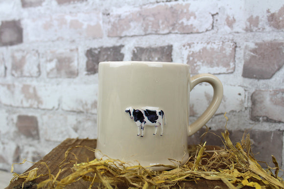 Stoneware mug showcasing a whimsical cow design, adding a touch of farmhouse-inspired coziness to your daily coffee or tea ritual.